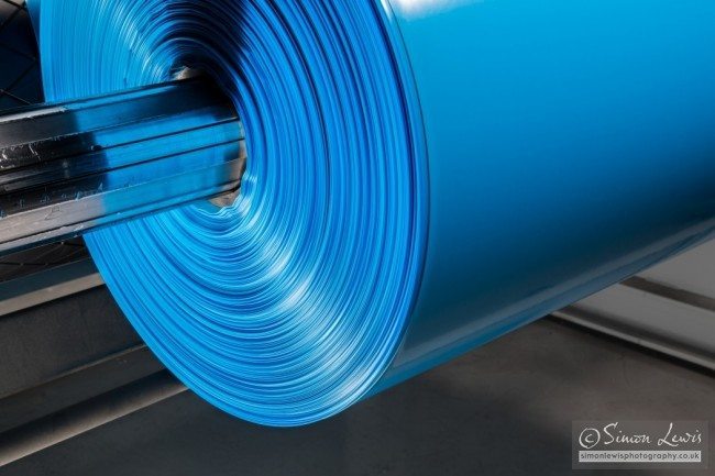 blue roll of plastic sheet being manufactured close-up