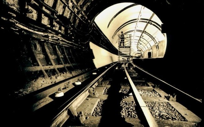 view along track inside london underground tunnel