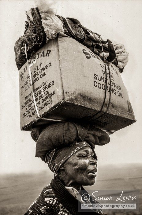 Transkei Lady carrying box on head walking
