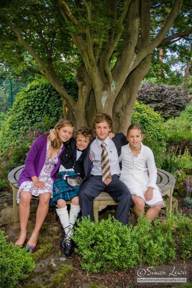 children group portrait in garden on bench arround tree