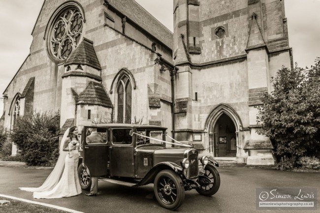 couple talking by car outside church sepia