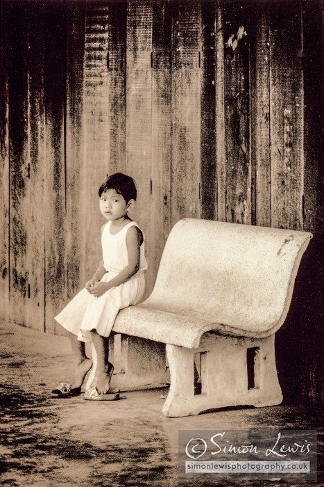 thai girl sitting at bus stop